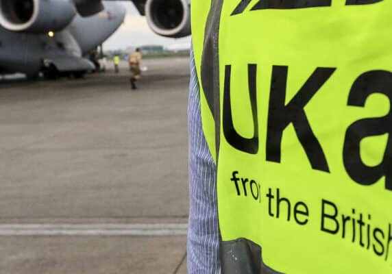 UK aid worker outside a plane