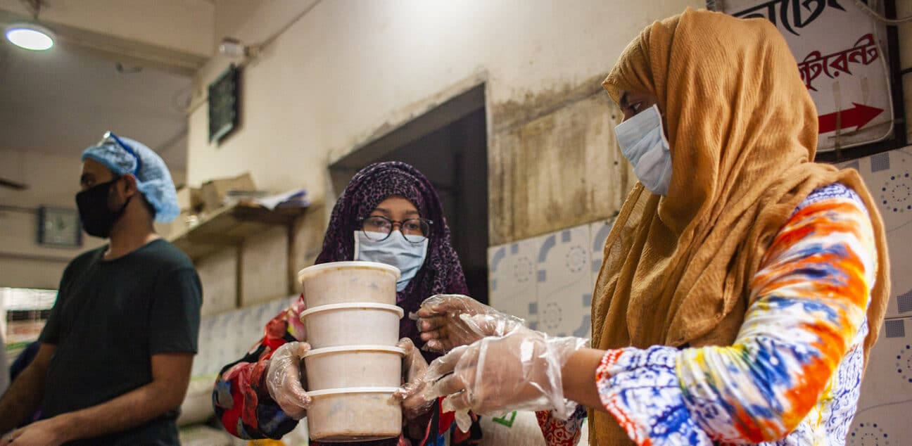 Volunteers at Bidyanando Foundation distributing cooked food in boxes to give to the marginalized people affected the most during the coronavirus pandemic.