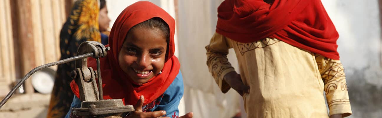 Children in Sindh, Pakistan, play at a water pump in a village.