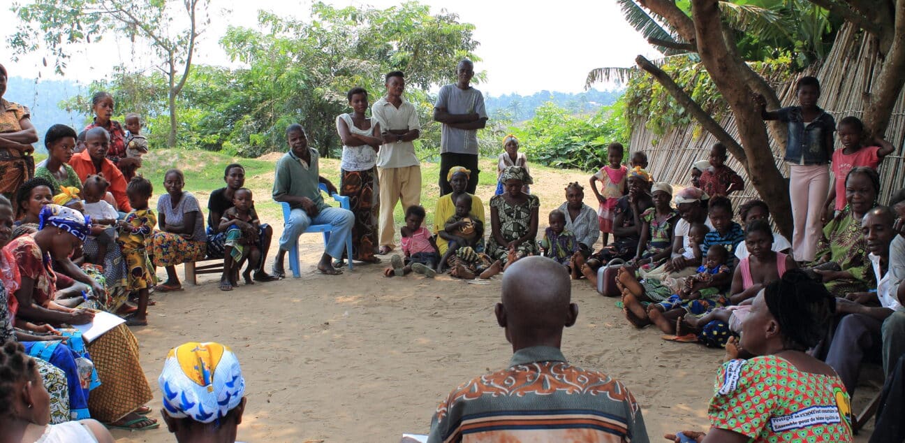 Discussing malnutrition in the shade of a mango tree.