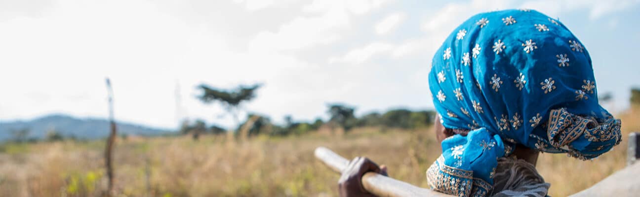 Florence, who with CAFOD’s help learned how to grow different crops to support herself on her own bit of land, going out into her farmland carrying a hoe.