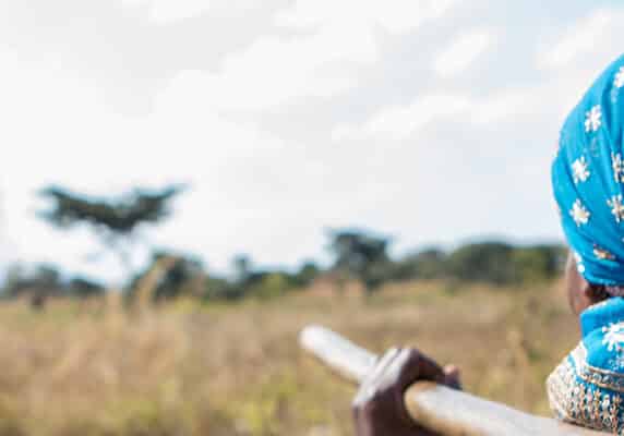 Florence, who with CAFOD’s help learned how to grow different crops to support herself on her own bit of land, going out into her farmland carrying a hoe.