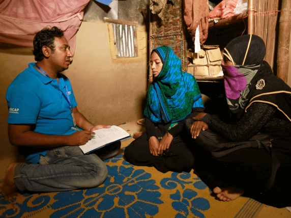 Man conducting an assessment with two women