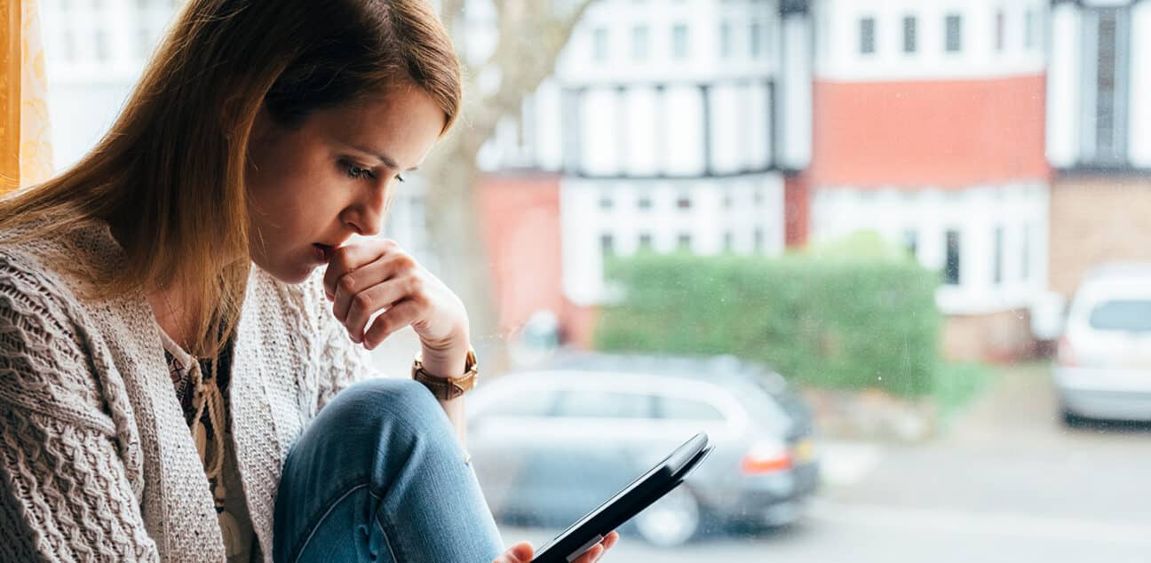 Woman sits with her phone