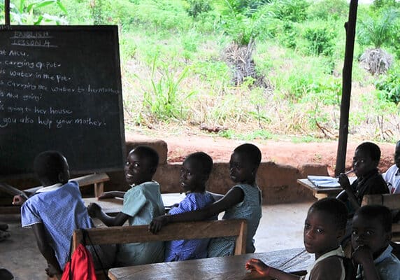 Students attending class in an outdoors elementary school classroom in the Yilo Krobo District near Accra, Ghana