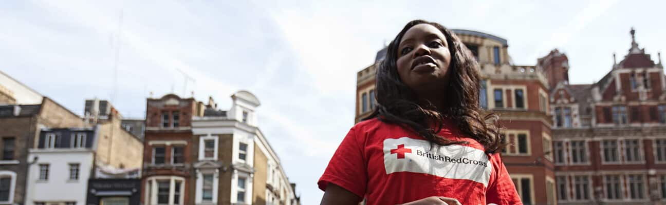 A woman with the British Red Cross takes a day away from the office to solicit for donations in front of the Liverpool Street Tube Station in London