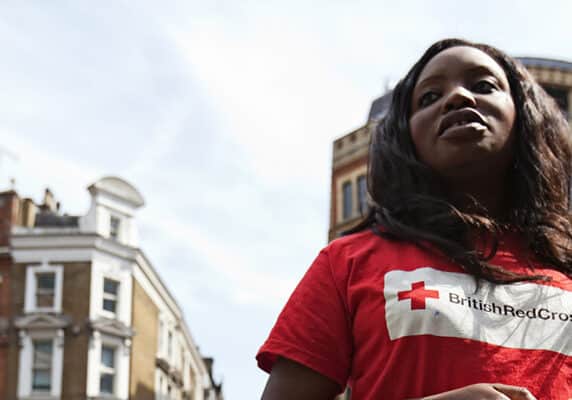 A woman with the British Red Cross takes a day away from the office to solicit for donations in front of the Liverpool Street Tube Station in London