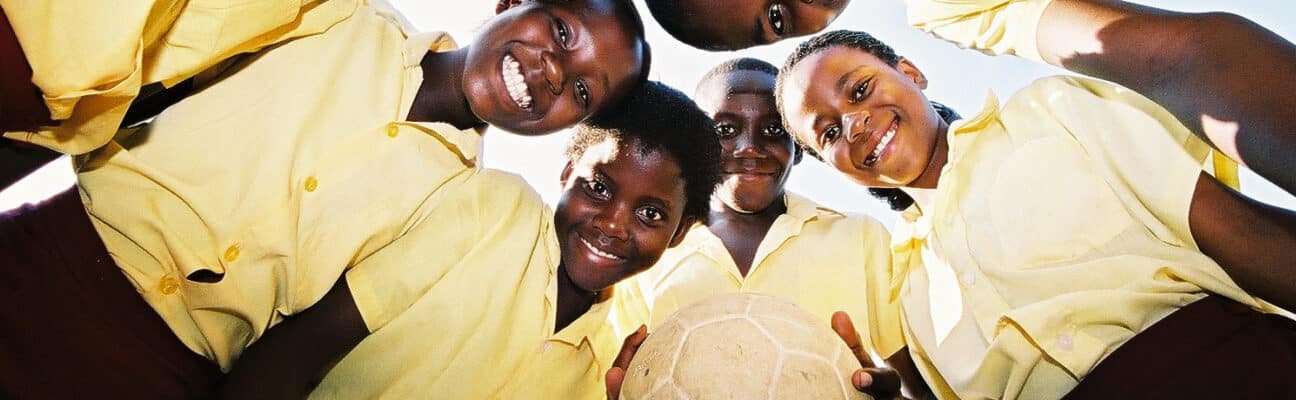 children stand in a circle with a football