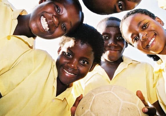 children stand in a circle with a football