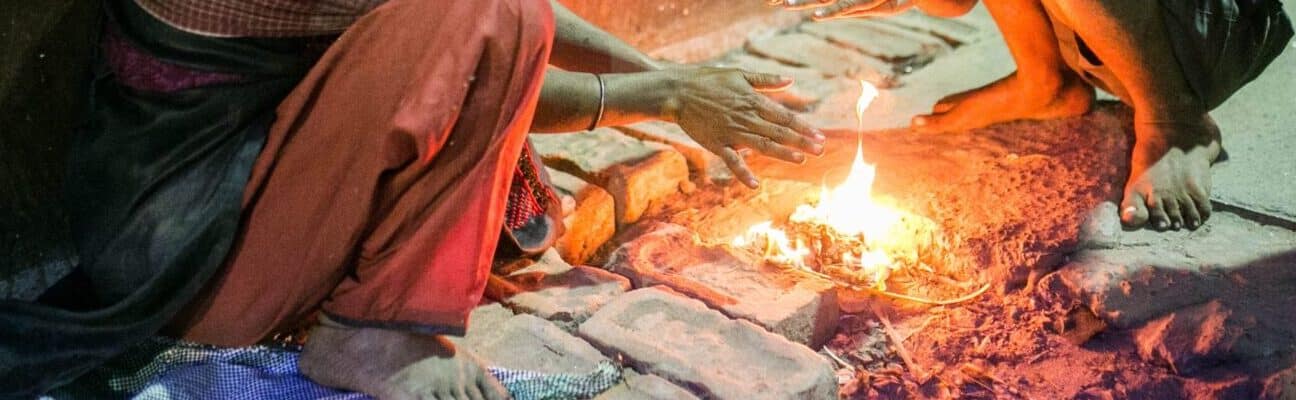 Children crouch over a small fire in Kolakata, India