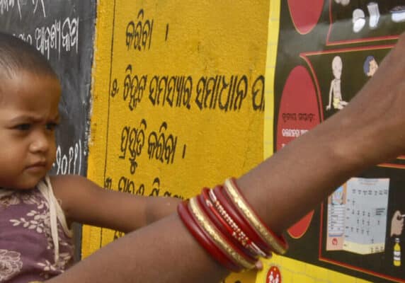 Woman reads a poster with a child