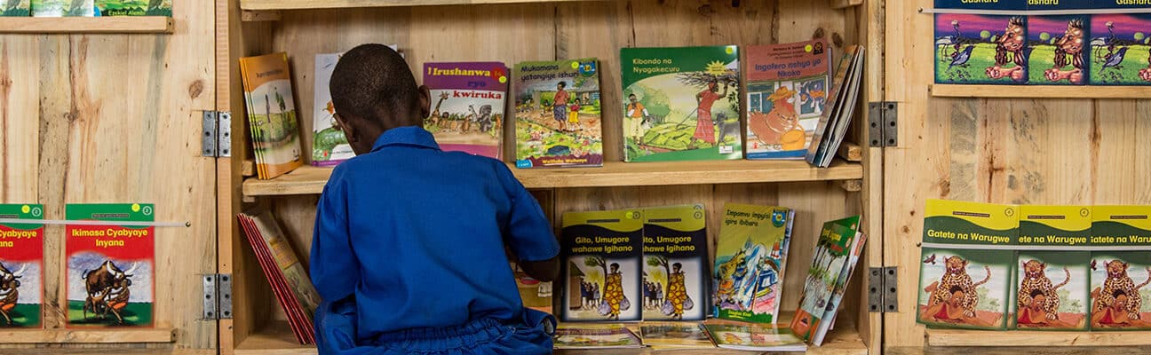 A student chooses a book from a cabinet at the Groupe Scolair Ruhanga school in Burera District of Rwanda.