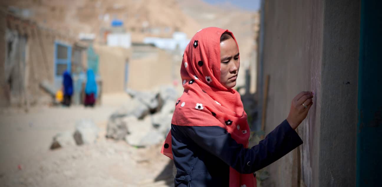 Woman marking a door in Afghanistan