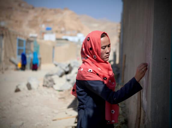 Woman marking a door in Afghanistan