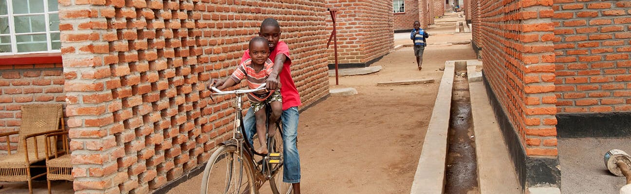 Two boys on a bike in new housing development in Malawi