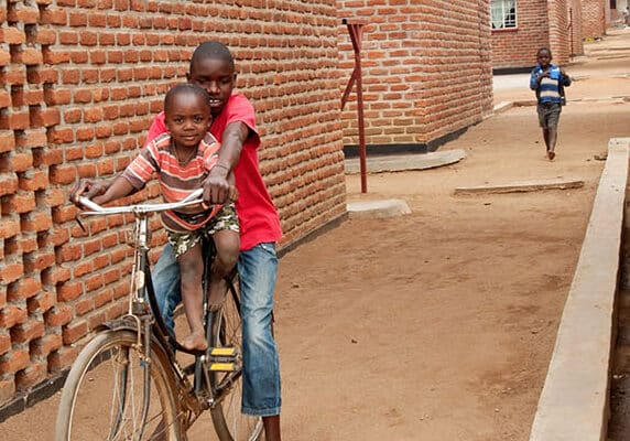 Two boys on a bike in new housing development in Malawi