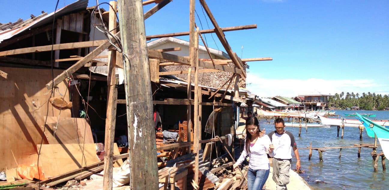 People through destroyed building after typhoon in Philippines