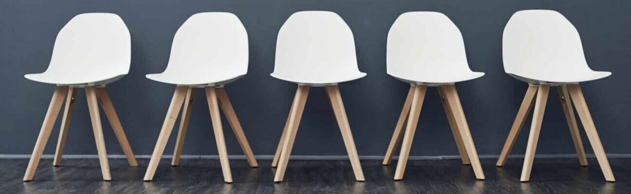 Shot of a row of empty chairs against a grey background