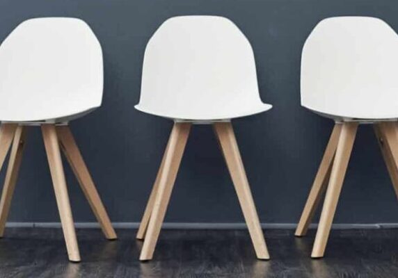 Shot of a row of empty chairs against a grey background