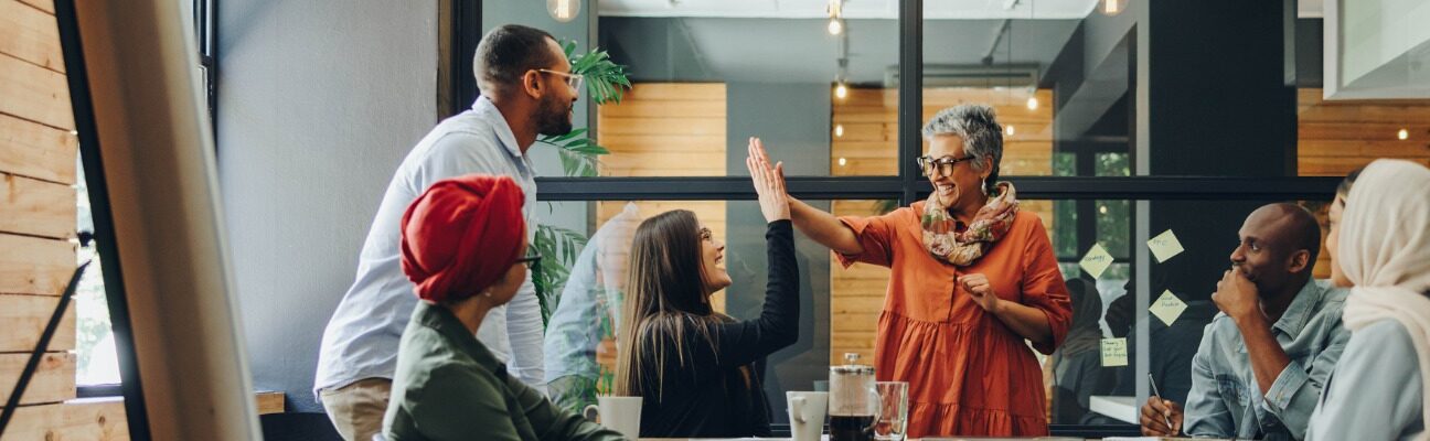 A team celebrates with a high five in an office