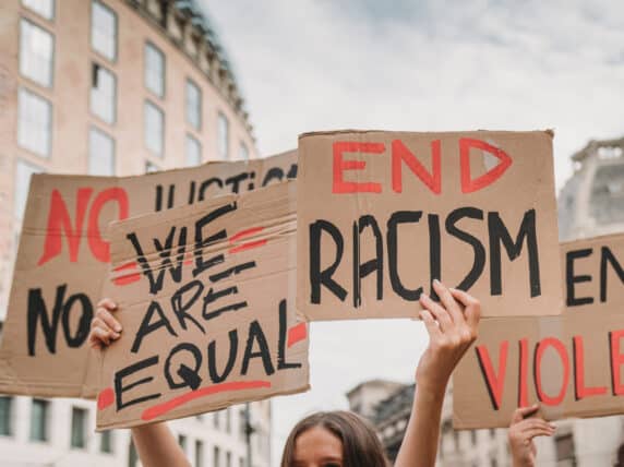 People marching on strike against racism in the city. They are holding cardboard signs. Credit: FilippoBacci