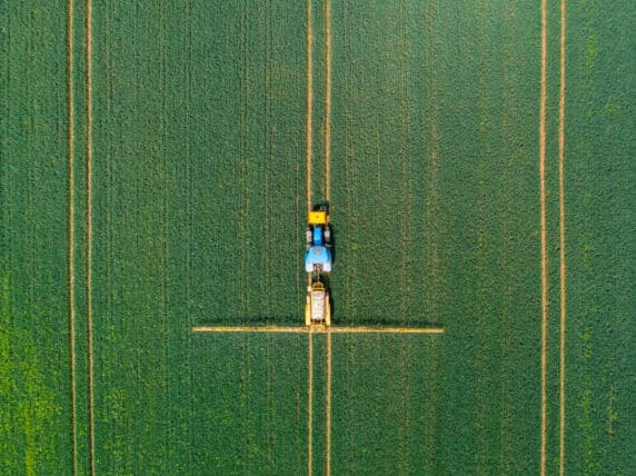 Aerial view of farming tractor crop sprayer in the countryside.