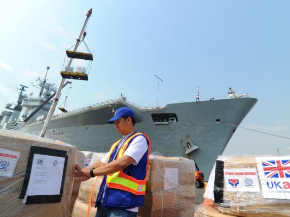 The Department for International Development’s (DFID) United Kingdom Aid (UKAid) unloads humanitarian aid in Manila. The pallets of shelter and repair kits, non-food items, and plant (including generators) came to the Philippines via HMS Illustrious, a 23,000-tonne aircraft carrier of the Royal Navy. © IOM 2013 / Ray Leyesa