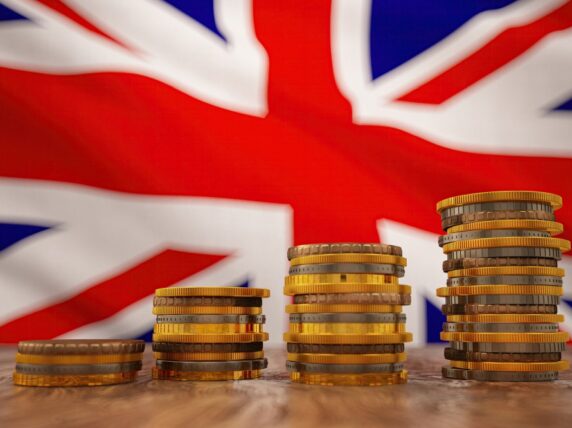 Stack of coins with British flag in the background