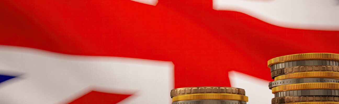 Stack of coins with British flag in the background