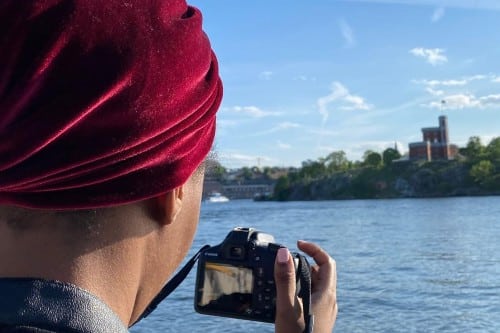 Person photographing a river view with a camera. Credit: Zainab Umar
