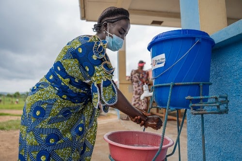 Marlene(25) washes her hands at a health centre following guidance on Ebola prevention. Credit: Save the Children