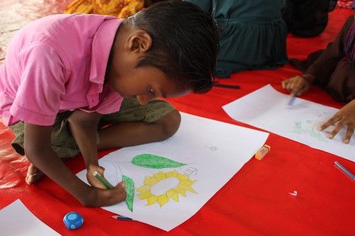 A boy from Sirajganj district in Bangladesh who is taking part in home-based education draws a sunflower. Credit: CDD